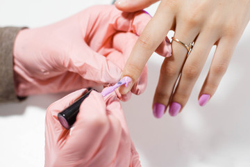 the master in the salon makes a manicure Nail polish coating. A big plan. Beautiful hands
