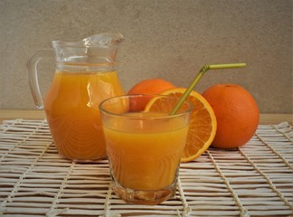 Freshly squeezed orange juice in a glass and jug.