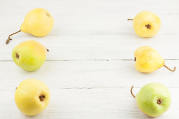 Two row of fresh ripe yellow whole pears on old rustic white wooden table