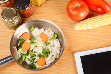 Vegetables and seasonings with a digital tablet.