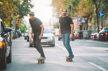 Two pro skateboard rider ride skate through cars on street