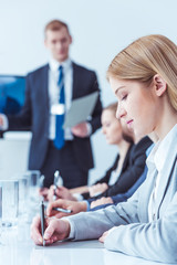 Woman writing down leader's guidelines