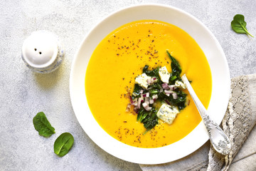 Pumpkin creamy soup with sauteed spinach and blue cheese.Top view.