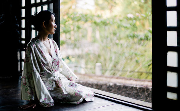 Beautiful Japanese woman in japanese house looking outside to the garden