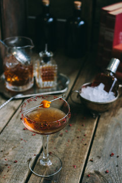 classic manhattan cocktail with orange peel on a wooden board