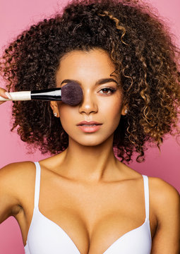 Portrait of the beautiful black woman with make-up brush near attractive face