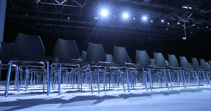 large Empty conference hall with rows of seats for spectators and audience.