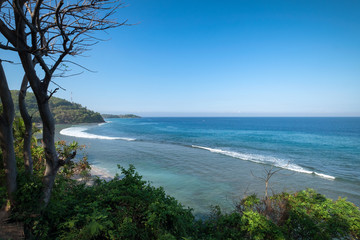 Beautiful landscape of blue beach with white sand and palm trees in Senggigi Beach at Lombok island, West Nusa Tenggara, Indonesia