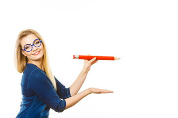 Positive woman holds big pencil in hand