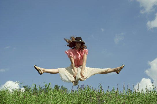 Girl jumping on the sunny meadow