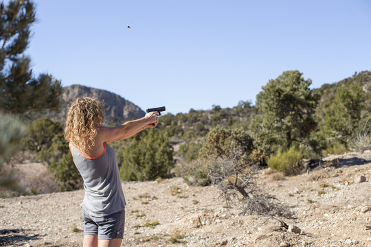 Woman shooting a handgun in the desert