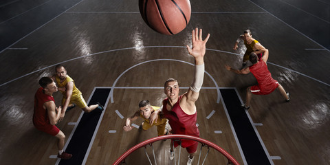 Basketball player makes slam dunk on big professional arena. Player flies through the air with the...