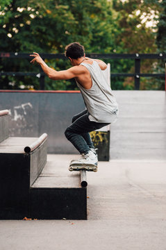 Caucasian man doing trick on his roller blades in skate park