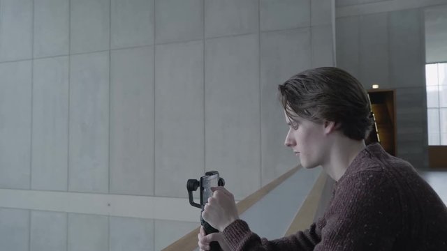 A man uses a gimbal stabilizer to shoot on a mobile device The technology of the future in a mobile photo and video