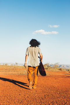 Long-Haired Man Holding Oud (Mandolin) and Walking Alone in Beautiful Countryside