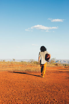 Long-Haired Man Holding Mandolin (Oud) and Walking Alone in Beautiful Countryside