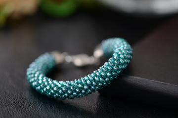 Beaded bracelet of aquamarine color on a dark background