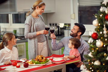 Wife with husband toasting with red wine during gala dinner
