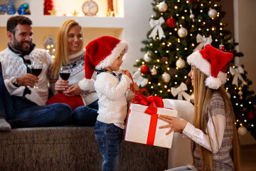 Fototapeta na wymiar Happy Christmas - Kids opening Christmas present.