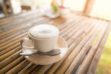Coffee cup on bamboo table in nature view