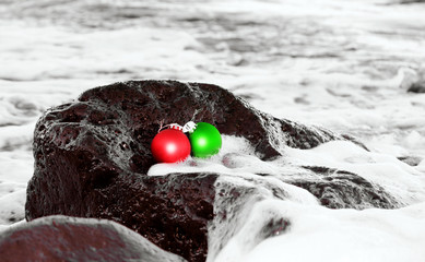 Red and green Christmas ornaments on the rock