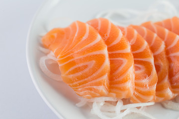 salmon sashimi, raw on a plate on a white background