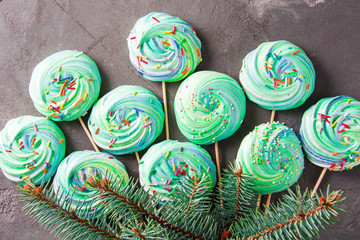 Green round meringues on a stick. Merry Christmas.
