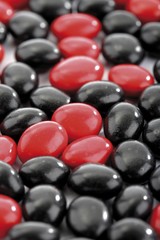 Red and black salmiak licorice candies, image-filling