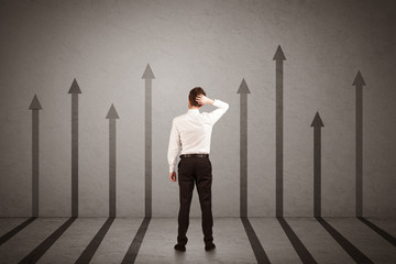 Sales person looking at arrows pointing up on the wall concept