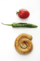 Rolled, fried bratwurst with hot pepper and cherry tomato