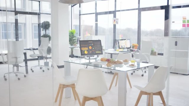  Interior empty office, desk laid with fruit & pastries for morning meeting