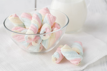 Twisted marshmallow in a cup on a light woden tray