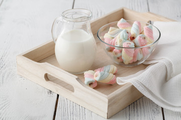 Wooden tray with a cup of milk and marshmallow