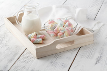 Twisted marshmallow in a cup on a light woden tray
