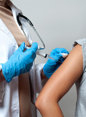 Vaccination. Doctor injecting flu vaccine to patient's arm.