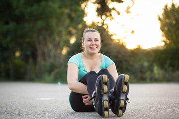 Young woman wearing / preparing her inline skates fot skating (sun-flare)