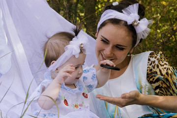 Obraz premium Little daughter play with mother on nature