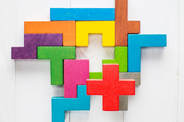 Obraz premium Different colorful shapes wooden blocks on white wooden background