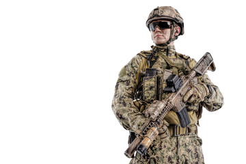 Half length low angle studio shot of special forces soldier in field uniforms with weapons, portrait isolated on white background lot of copyspace. Protective goggles glasses are on
