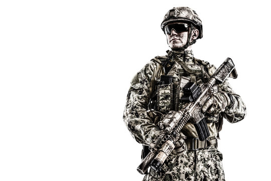 Half length low angle studio shot of special forces soldier in field uniforms with weapons, portrait isolated on white background lot of copyspace. Protective goggles glasses are on