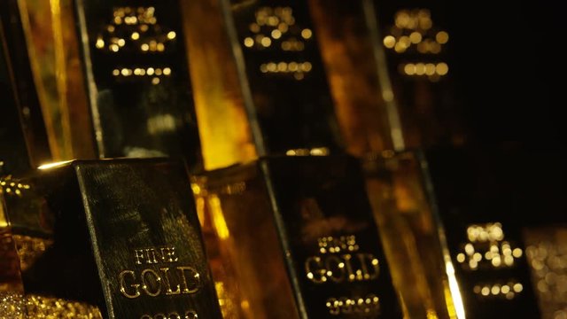  Close up gold bars on shimmering rotating stand, wealth & luxury concept.