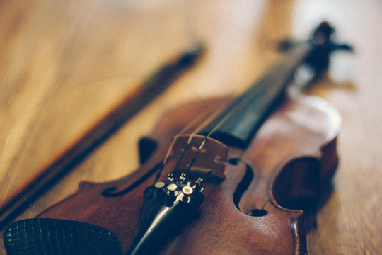 Old violin lying on a wooden surface