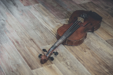 Fototapeta na wymiar Old violin lying on a wooden surface