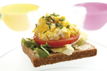 Scrambled eggs on toast with tomatoes and chives