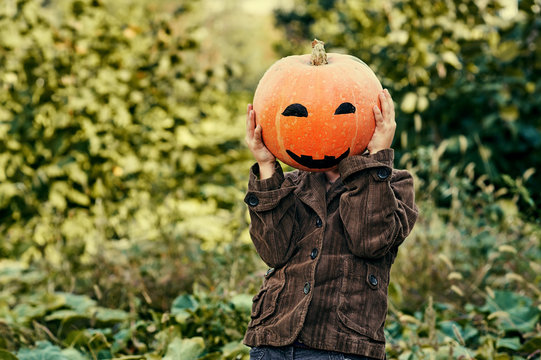 Boy holding a pumpkin on Halloween