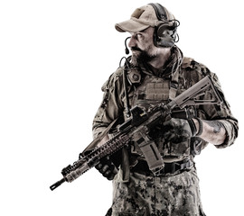 Half length low angle studio shot of special forces soldier in field uniforms with weapons on his...