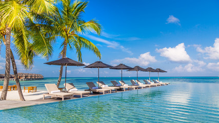 Fototapeta na wymiar Luxury poolside with beach background