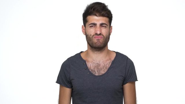 caucasian bearded guy with chest hair under grey t-shirt nodding negatively expressing total rejection gesturing to stop over white background. Concept of emotions