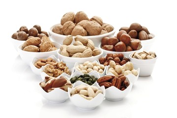 Assorted nuts and kernels in ceramic bowls, pecans, walnuts, hazelnuts, macadamia nuts, peanuts, almonds, pistachios, and Brazil nuts