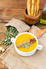 bowl of delicious pumpkin soup. Rustic background